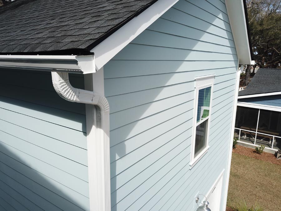 Close up of white gutter system and downspout.