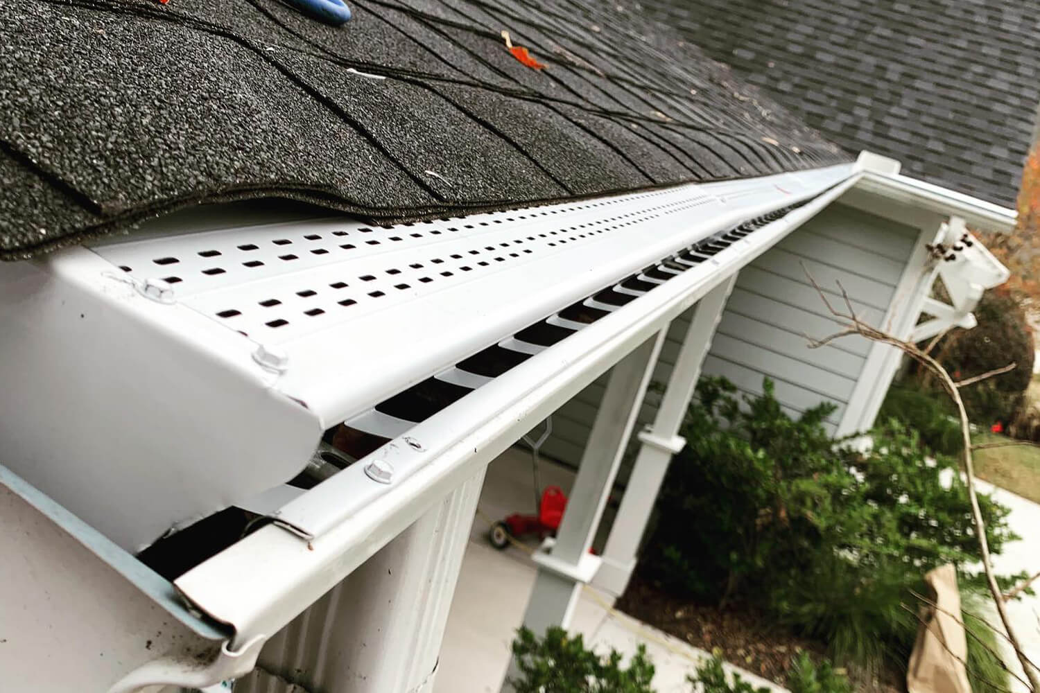 Close up of white gutter system with protective guard.